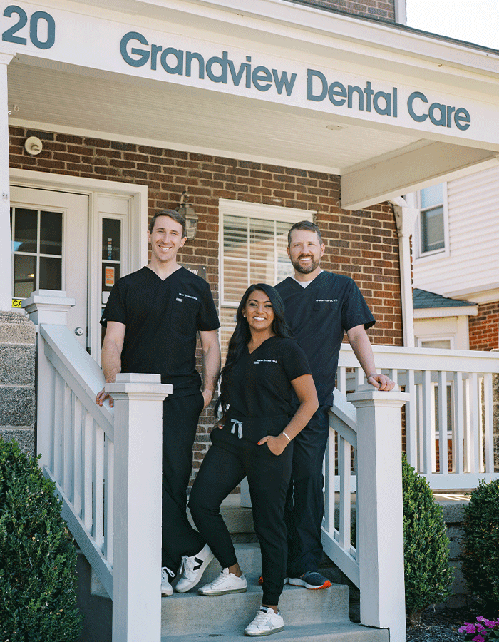 Drs. Max Grosel, Nisha Grsel, and Abraham Hoellrich standing in front of Grandview Dental Care in Columbus, OH.